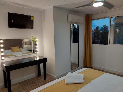 a bedroom with a desk and a bed and a window at Hostal GARDEN ROUS in Paiporta