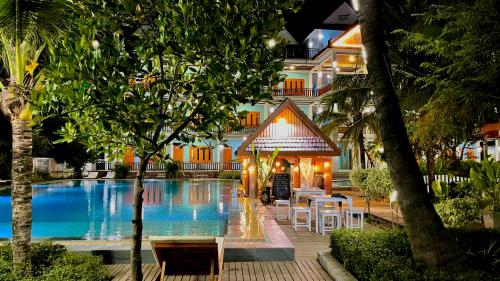 a hotel with a swimming pool in front of a building at Nakasang Paradise Hotel in Nakasong