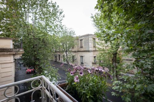 a balcony with a flower garden on a city street at B&b Morosoli Palace in Catania