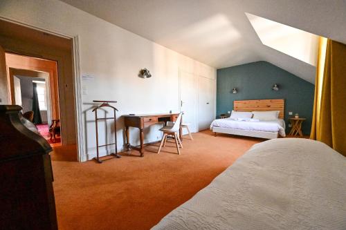 a bedroom with a bed and a desk in it at Auberge Bretonne in La Roche-Bernard