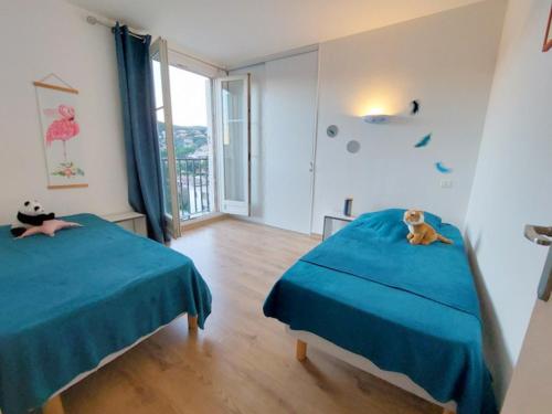 - une chambre avec 2 lits avec un chat dans l'établissement CAPET LES DAHLIAS - Axelle Loc'Appart, à Sainte-Maxime
