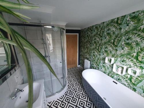a bathroom with a tub and a green plant at Belle Vue Cottage in Downham Market