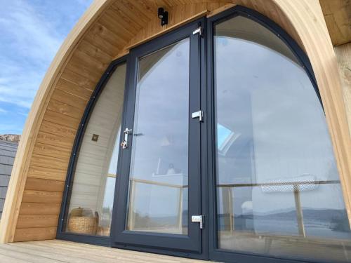 an arched glass door in a house at Sunset Cabin- glass frontage luxury couples cabin. in Shieldaig