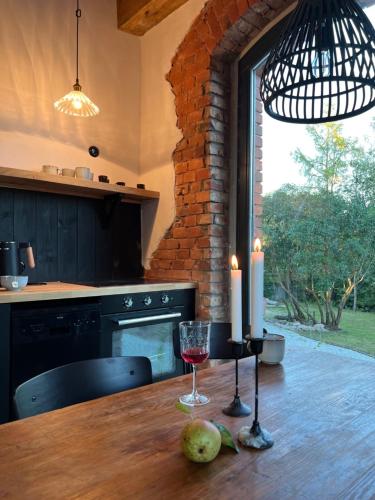 a kitchen with a table with two candles and a glass of wine at Ublik Stacja in Ublik