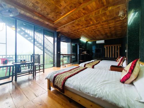 1 dormitorio con 2 camas en una habitación con ventanas grandes en Hoàng Hà Hotel Tam Đảo en Tam Ðảo