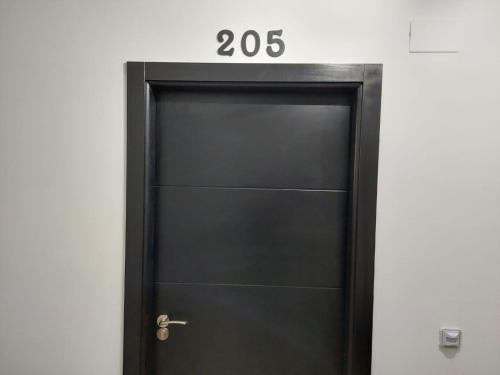 a black door with a sign on top of it at Hostal GARDEN ROUS in Paiporta