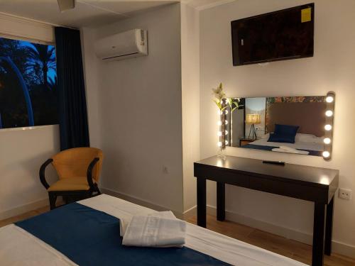 a bedroom with a desk and a bed with a mirror at Hostal GARDEN ROUS in Paiporta
