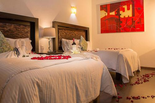 a hotel room with two beds with red roses on them at M Hoteles Concepto in Morelia