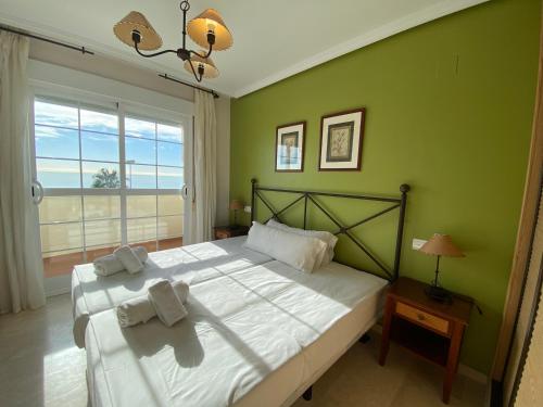 ベナルマデナにあるPanoramic Penthouseの緑の壁のベッドルーム1室(大型ベッド1台付)