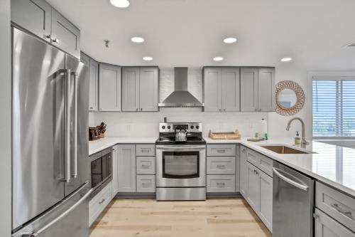 a kitchen with white cabinets and a stainless steel refrigerator at Sand Dollar 501 in Clearwater Beach