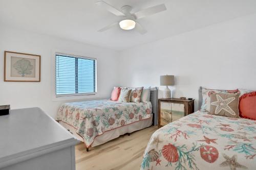 a bedroom with two beds and a ceiling fan at Sand Dollar 501 in Clearwater Beach