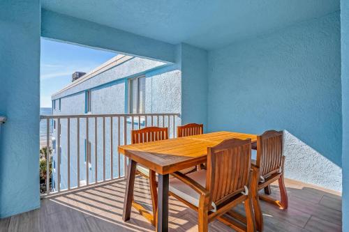 a wooden dining room table with chairs on a balcony at Sand Dollar 501 in Clearwater Beach