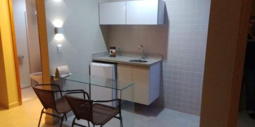 a kitchen with a glass table and two chairs at Hot Springs B3 Apart in Caldas Novas