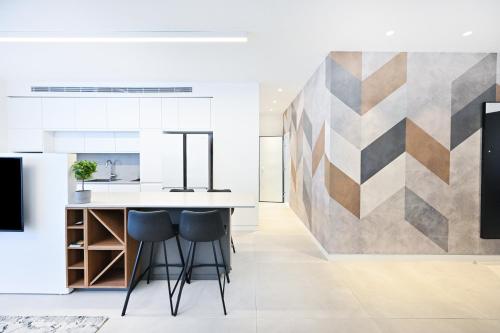 a kitchen with a counter and stools at Hotel comfort by HolyGuest in Tel Aviv