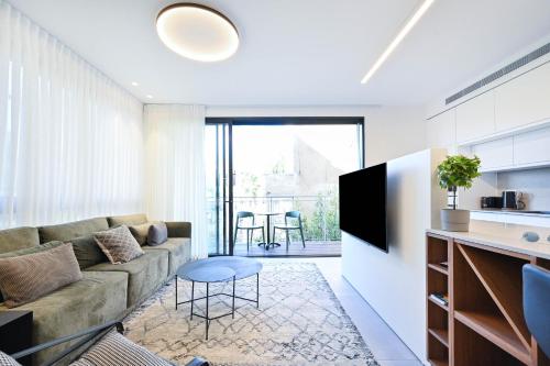 a living room with a couch and a table at Hotel comfort by HolyGuest in Tel Aviv