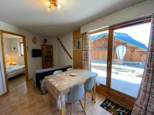 un salon avec une table et une grande fenêtre dans l'établissement Appartement cosy avec Multi Pass offert, à 10 minutes du centre de Châtel et proche des remontées - FR-1-693-7, à Châtel