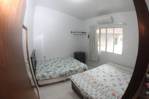 Katil atau katil-katil dalam bilik di Bruno Klemtz Casa frente Mar Pé na areia Lindo pátio com gramado privativo Ar Split WIFi - 6 x sem juros