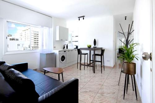 uma sala de estar com um sofá, uma mesa e uma cozinha em Urban Condo 43 - 1 Bdr em Nicósia