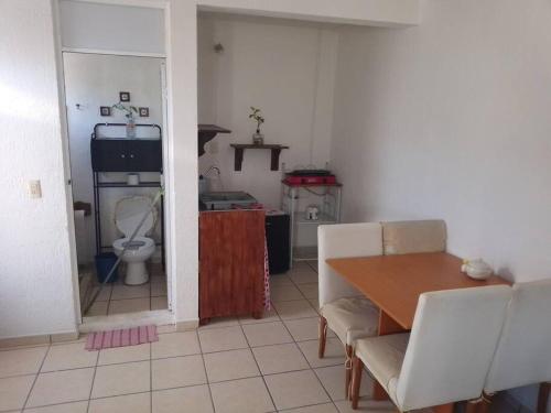 een woonkamer met een tafel en een keuken met een toilet bij Sweet Home in Tequisquiapan