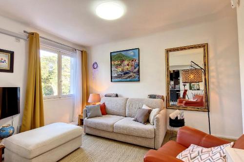 un soggiorno con divano e specchio di HENRI CAMILLE REAL ESTATE - ALEXANDRA - 2 bedrooms a Cannes