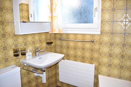 une salle de bain avec un lavabo et un miroir dans l'établissement Lodola 298 2 Hk , Wohnung 2, à Lenzerheide