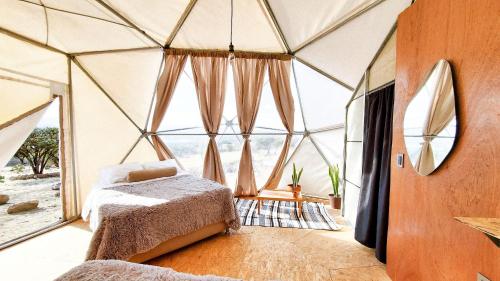 a bedroom in a yurt with a bed and windows at Mars Glam Camp in Aguascalientes