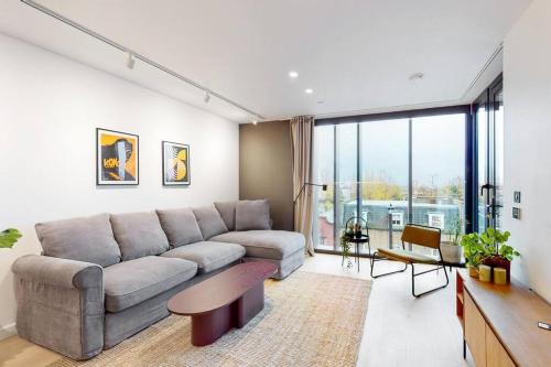 a living room with a couch and a table at Modern 1 bed flat with balcony in Kensal Green in London