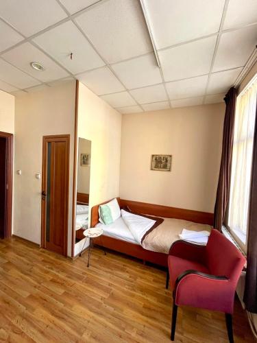 a room with a bed and a chair in it at Rooms Sonata in Kyustendil
