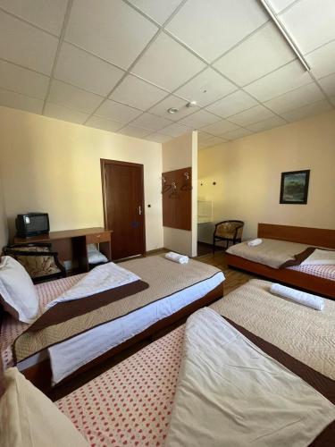 a large room with three beds in it at Rooms Sonata in Kyustendil