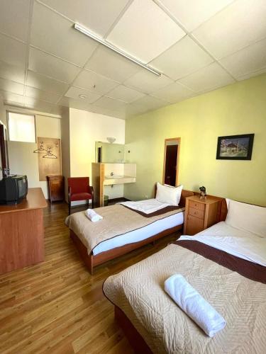 a hotel room with two beds and a television at Rooms Sonata in Kyustendil