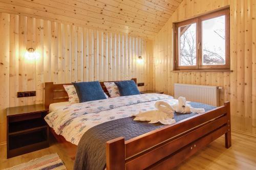 a bedroom with a bed with two stuffed animals on it at Apartment Stone and Wood in Cetingrad