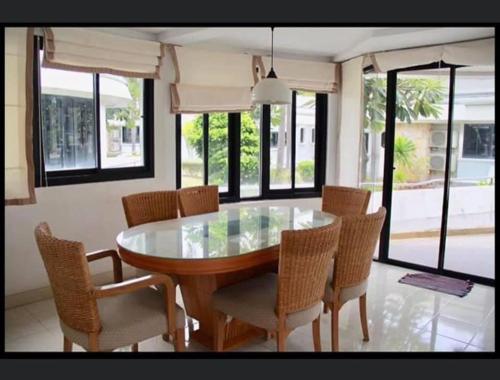 ein Esszimmer mit Glastisch und Stühlen in der Unterkunft บ้านนาวาภิรมย์ ชะอํา in Ban Khlong Khot