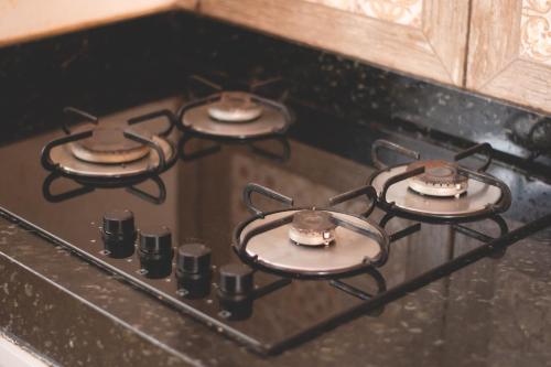 a stove top with four burners on top of it at Casa Da Cléo Carrancas in Carrancas