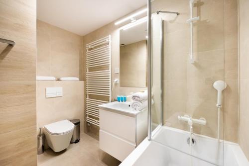 La salle de bains est pourvue d'une douche, de toilettes et d'un lavabo. dans l'établissement Unique Tower 22 Floor De Luxe Apartment, à Varsovie