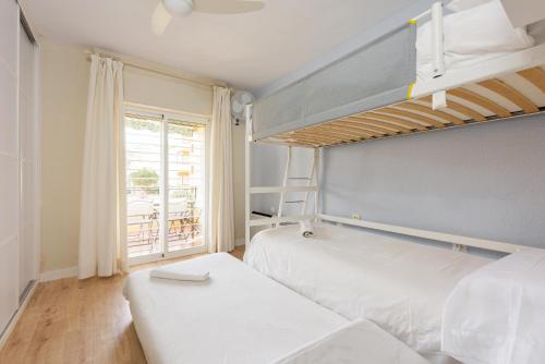 a bedroom with two bunk beds and a balcony at Stay U-nique apartment Venezuela in Málaga