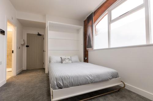 een slaapkamer met een bed en een raam bij Platform City Theatre Studio with Secure Parking in Hull