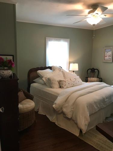 a bedroom with a bed with a ceiling fan and a window at Sweet Dreams Bed and Breakfast Cutchogue in Cutchogue