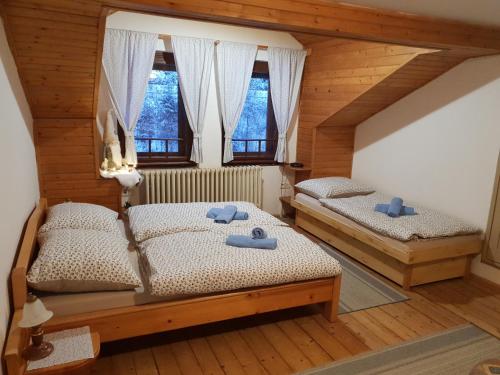 two twin beds in a room with two windows at Penzión Šafran in Stratená