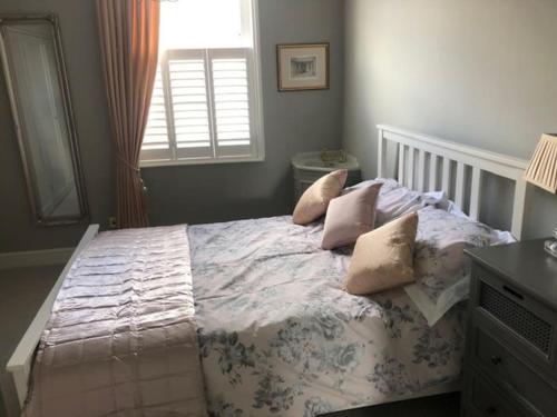 1 dormitorio con cama con almohadas y ventana en Luxury 2 bed Georgian Townhouse, Old Portsmouth en Portsmouth