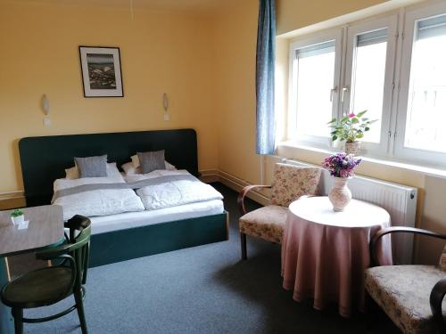 Schlafzimmer mit einem Bett, einem Tisch und Stühlen in der Unterkunft Bianco in Sopron