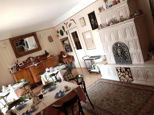 ein Esszimmer mit 2 Tischen und einem Kamin in der Unterkunft Bianco in Sopron