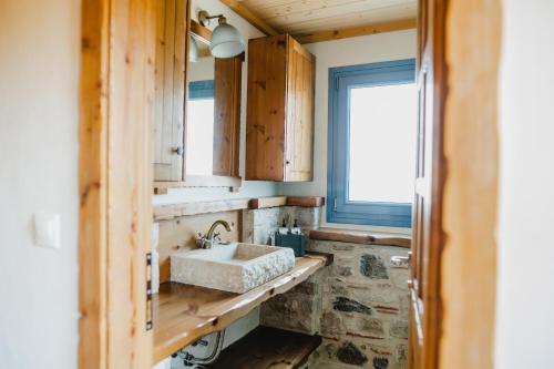 a bathroom with a sink and a window at Chaihoutes stone villa into Olive farm in Zia in Ágios Dimítrios