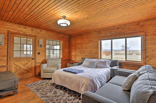 a bedroom with a bed and a couch and a window at Secluded Cabin with Hot Tub, Game Room and Views! in Durango