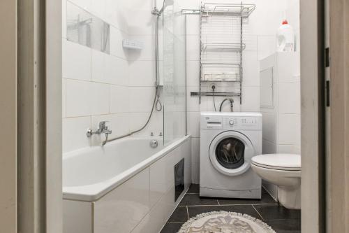ein weißes Bad mit einer Waschmaschine in der Unterkunft Joyful 2BR Apt. @ Millenium Tower and The Danube in Wien