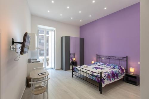 una camera da letto con un letto e una parete viola di MY BRILLIANT HOME WITH JACUZZI 2 STEPS FROM St TOLEDO a Napoli