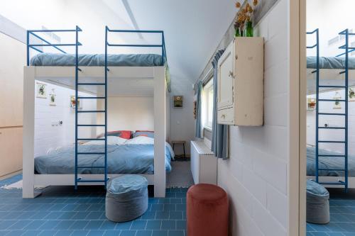 Origineel gerenoveerde schuur nabij Antwerpen في Zoersel: سريرين بطابقين في غرفة مع سرير