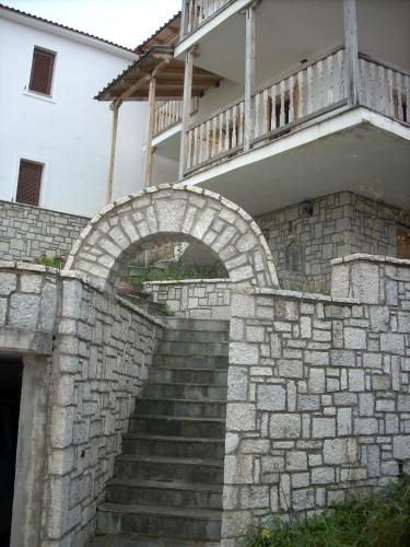 una escalera de piedra que conduce a un edificio con balcón en Μεζονέτα στην λίμνη Πλαστήρα, en Neráïda