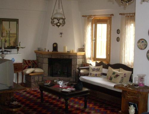 sala de estar con sofá y chimenea en Μεζονέτα στην λίμνη Πλαστήρα, en Neráïda