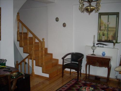 a living room with a staircase and a chair at Μεζονέτα στην λίμνη Πλαστήρα in Neráïda
