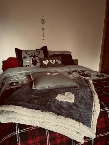 a bed with a blanket and pillows on it at L'instant présent in Echallon